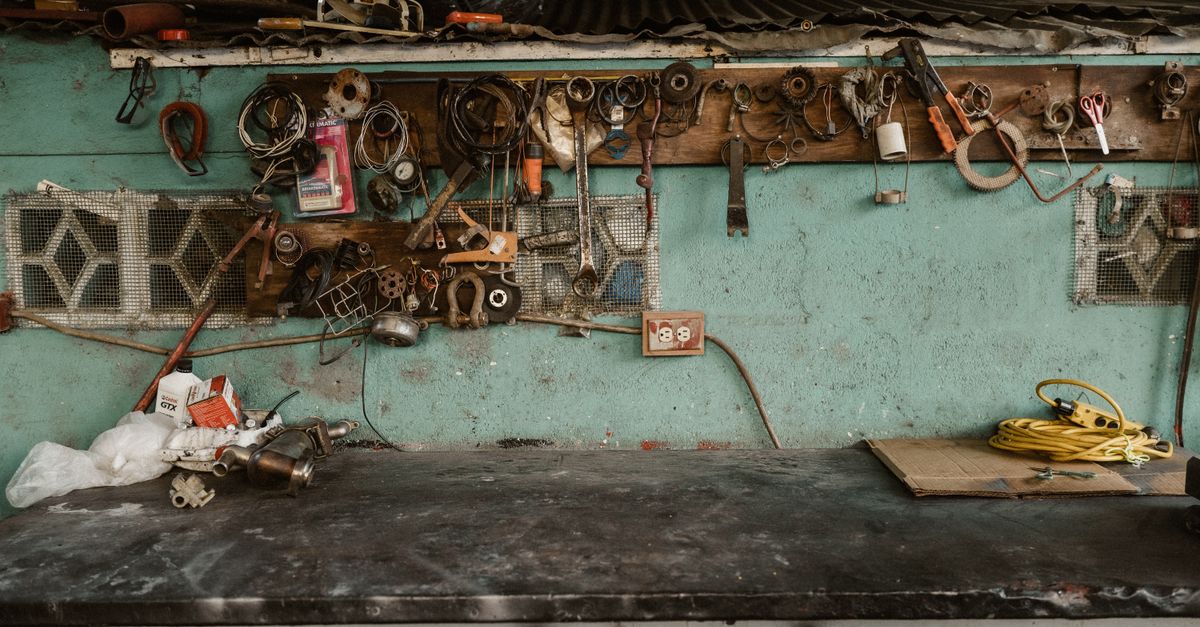 Rustic workshop scene with tools and accessories arranged on a wall rack.